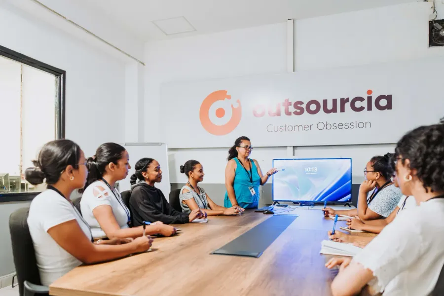 Session de formation animée devant une équipe, dans une salle aux couleurs Outsourcia